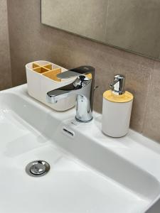 a bathroom sink with a faucet on top of it at Olympic Beach Rooms in Olympic Beach +58 photos