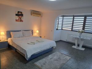 a bedroom with a bed and a table with two lamps at CASA ROTARU in 2 Mai