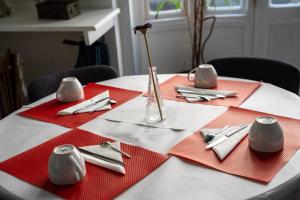a table with red napkins and a vase with a flower on it at Le National Sète Centre Gare,Ascenseur in Sète