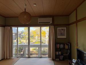 a living room with a large window with a view at 麻心家azamiya in Nagao