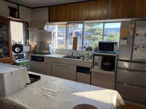 a kitchen with a refrigerator and a sink in it at 麻心家azamiya in Nagao