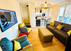 a living room with a couch and a kitchen at L'Écrin du Petit Prince SoCozy in Toulouse