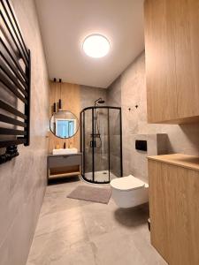 a bathroom with a shower and a toilet and a sink at Marina Augustów - BRYZA in Augustów +35 photos