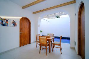 a dining room with a table and chairs at Serenity Garden Villas by Danka Hospitality in Hang Nadim International Airport
