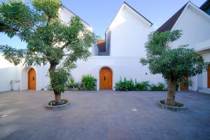 two trees in a courtyard in front of a building at Serenity Garden Villas by Danka Hospitality in Hang Nadim International Airport