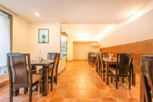 a dining room with wooden tables and chairs at Treebo Ivy Castle in Gurgaon