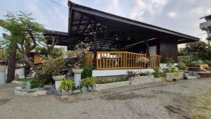 a house with a porch with potted plants in front at Beachfront Aircon Kubo for 4pax in Caba