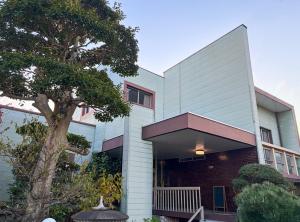 a building with a tree in front of it at 麻心家azamiya in Nagao