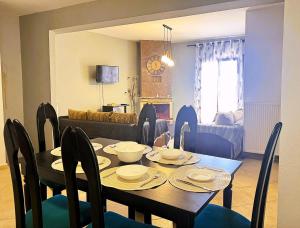 a dining room with a table with chairs and a couch at Villa Galani Afitos in Afitos