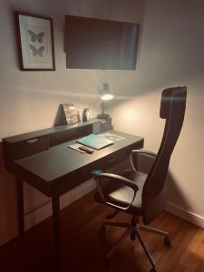 a office with a desk with a chair and a lamp at Au petit Chapeau Rouge in Clisson +6 photos