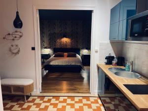 a bedroom with a bed and a sink in a room at Au petit Chapeau Rouge in Clisson