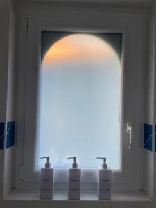 a window in a bathroom with two soap bottles at Au petit Chapeau Rouge in Clisson