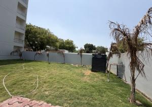 a yard with a fence and a tree at Sky Homestay in Noida