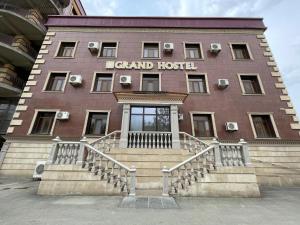 a large building with stairs in front of it at ATB Grand Hostel in Atyrau