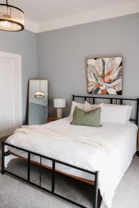 a bedroom with a large bed with white sheets at Charm on Forster in Invermay