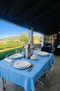 a table with plates and a bucket of wine bottles at Villa Beafe' Ogliastra con piscina in Tertenìa