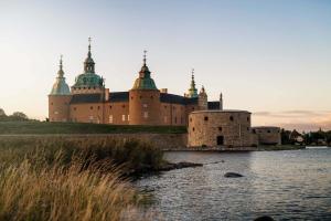 a large castle sitting on top of a body of water at Fantastic accommodation in central Kalmar in Kalmar