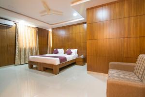 a bedroom with a bed and a couch in it at Shoba Tulip Hebbal in Bengaluru +23 photos