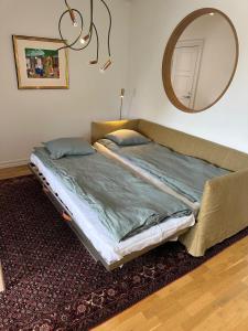 a bed sitting in a room with a mirror at Fantastic accommodation in central Kalmar in Kalmar