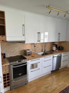 a kitchen with white cabinets and stainless steel appliances at Fantastic accommodation in central Kalmar in Kalmar +20 photos