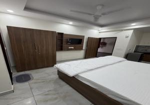 a bedroom with a large bed and a flat screen tv at Sky Homestay in Noida