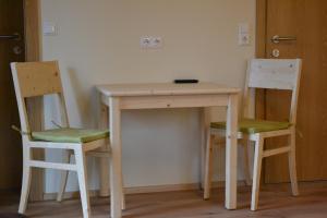 un tavolo in legno con 2 sedie e un tavolo di Pension Adlerhorst a Ramsau am Dachstein