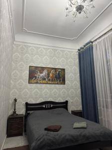 a bedroom with a bed and a painting on the wall at Апартаменти в парку in Uman