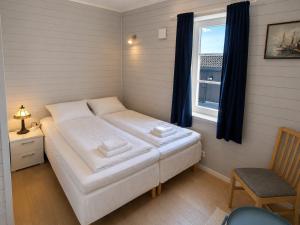 a bedroom with a white bed and a window at Golsfjellet Apartment with Sauna in Gol