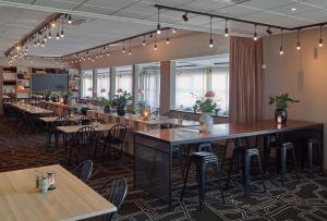 a restaurant with tables and chairs in a room at Scandic Norrköping Nord in Norrköping