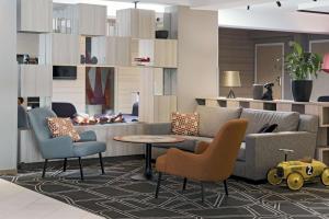 a living room with a couch and chairs and a table at Scandic Norrköping Nord in Norrköping