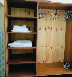 a closet with wooden shelves and white towels at Summer Studio Suit in Malindi