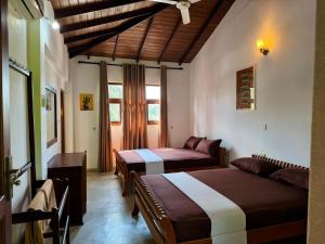 a hotel room with two beds and a couch at Rupas Hotel in Arugam Bay +69 photos