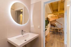 a bathroom with a sink and a mirror at Apartamentos La Botica in Comillas +25 photos