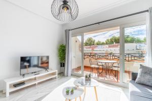 a living room with a couch and a tv and a balcony at Calpe Bay Masnou 24 in Calpe