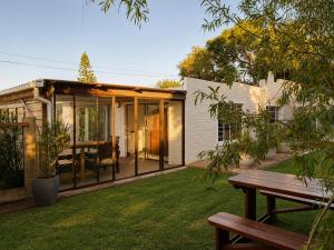 a house with glass doors and a bench in a yard at Serenity Stay- Walmer in Gqeberha