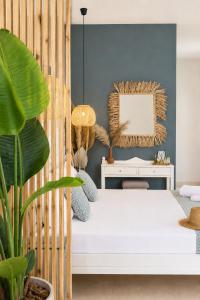 a bedroom with a white bed and a plant at Kurmulis Studios in Stalos