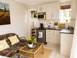 a living room with a couch and a kitchen at Serenity Stay- Walmer in Gqeberha