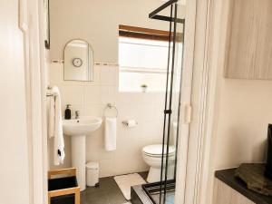 a bathroom with a toilet and a sink at Serenity Stay- Walmer in Gqeberha +35 photos
