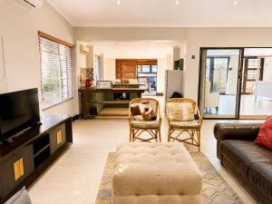 a living room with a couch and a tv at Serenity Stay- Walmer in Gqeberha