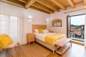 a bedroom with a bed and a large window at Apartamentos La Botica in Comillas