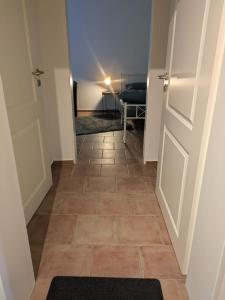 a hallway with a door and a tiled floor at Lutz Appartements Südheide - Einzelzimmer in Gifhorn