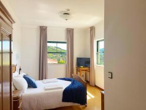 ein Hotelzimmer mit einem Bett und einem Fenster in der Unterkunft Vinhais Hotel in Vinhais