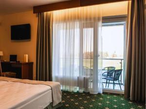 a hotel room with a bed and a window with a balcony at SPA Amber Palace in Šventoji +68 photos