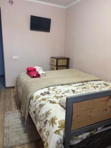 a bedroom with a bed with a tv on the wall at Lucy Guest House in Garni