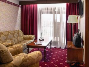 a living room with a couch and a table at SPA Amber Palace in Šventoji