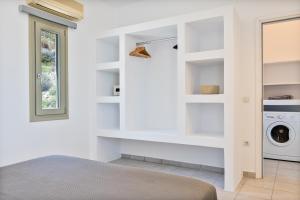 a white laundry room with a washer and dryer at Lagadia Village in Antiparos