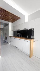 a large kitchen with white cabinets and wooden counter tops at Apartament Sun Hill in Wisła