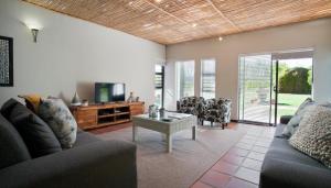 a living room with two couches and a tv at Rest at Chabivin in Stellenbosch