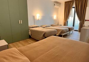 a hotel room with three beds in a room at B&B Mastro Mario in Rocca di Neto