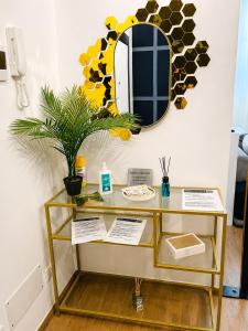 a shelf with a mirror and a plant on a wall at Rebecca's Noir Suite in Reggio Emilia